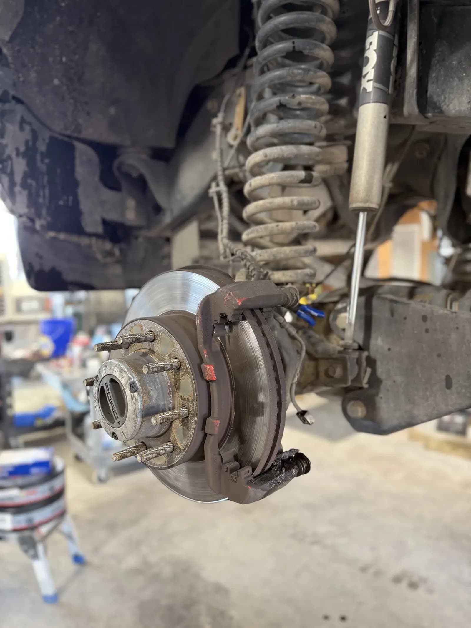Brake rotor and caliper exposed during brake service on a truck
