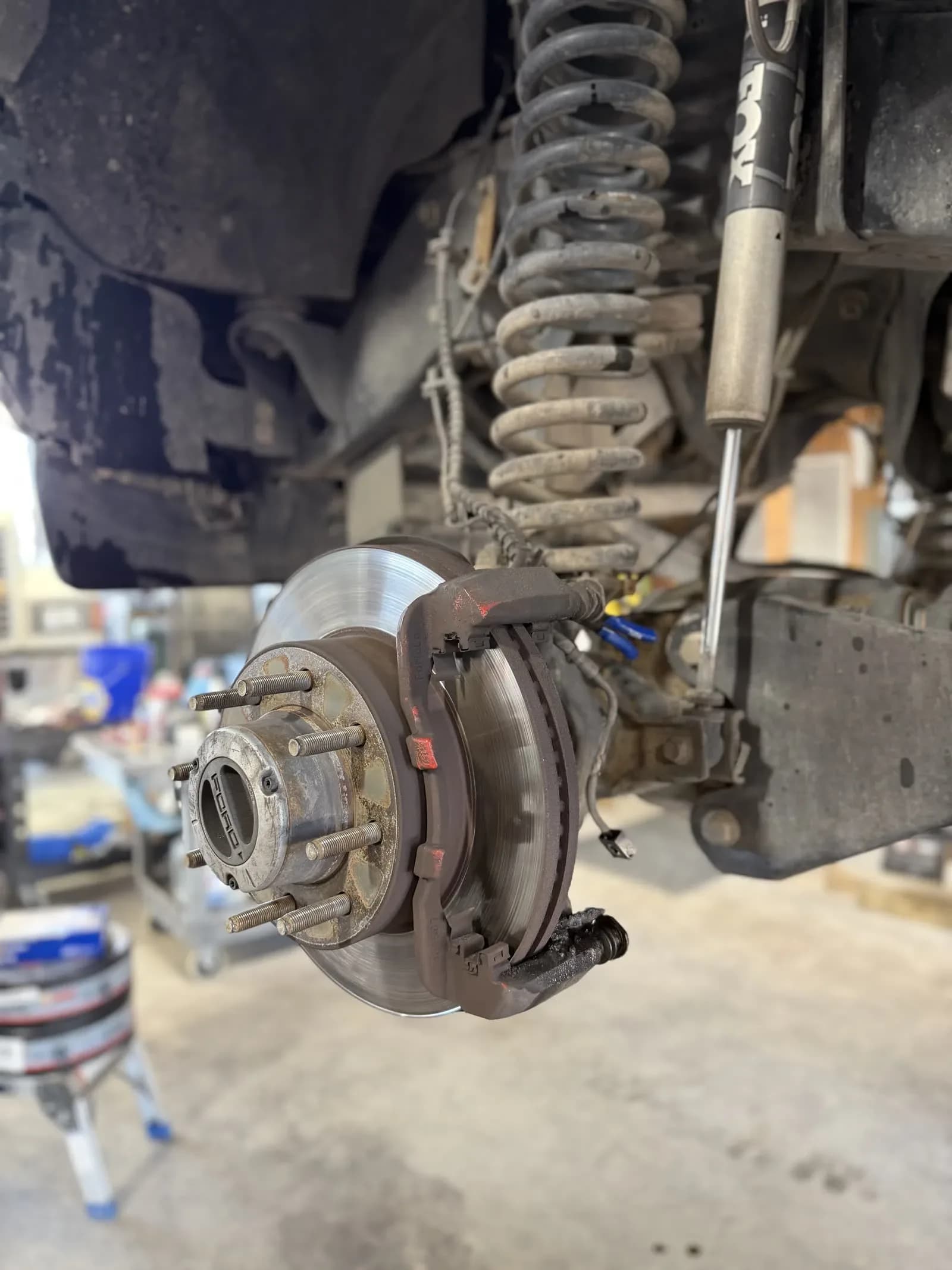Brake rotor and caliper exposed during brake service on a truck