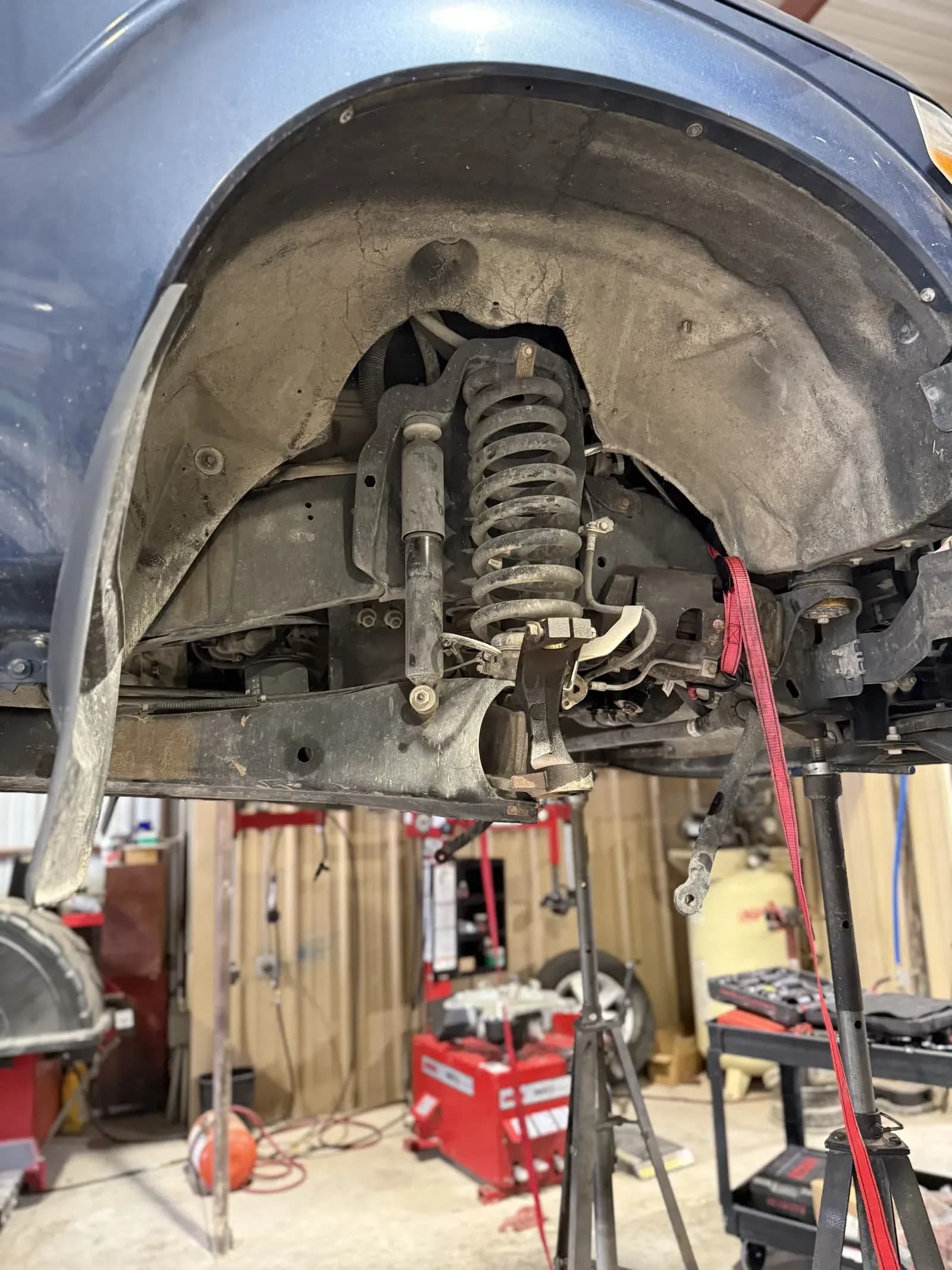 Coil spring and suspension components in a truck wheel well during repair