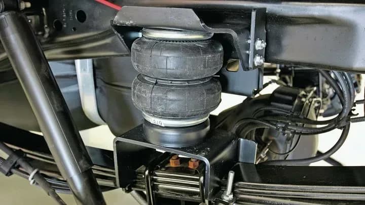 Air-helper spring installed between the frame and leaf springs of a pickup truck