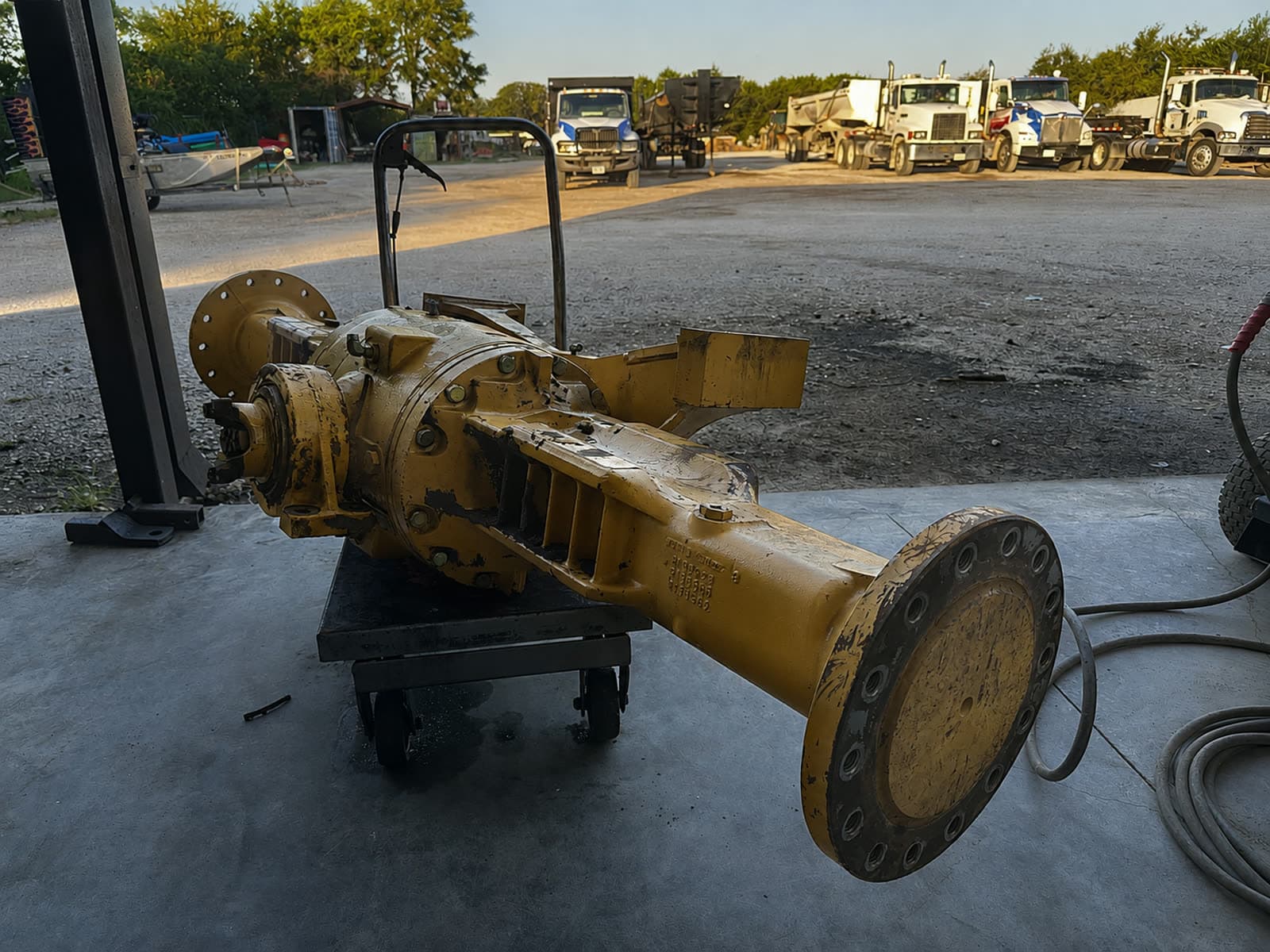 Heavy-equipment axle assembly on a cart during drivetrain repair at Quality Mechanics